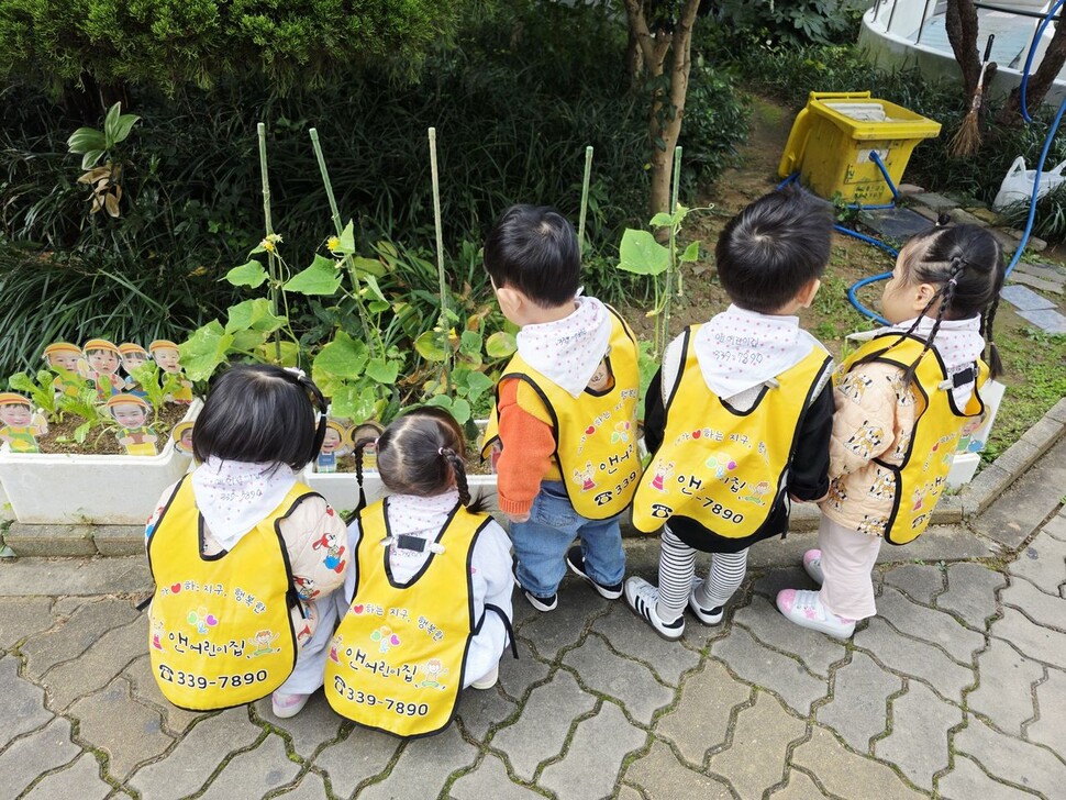 텃밭에서 자라는 식물을 살펴보는 아이들 모습.